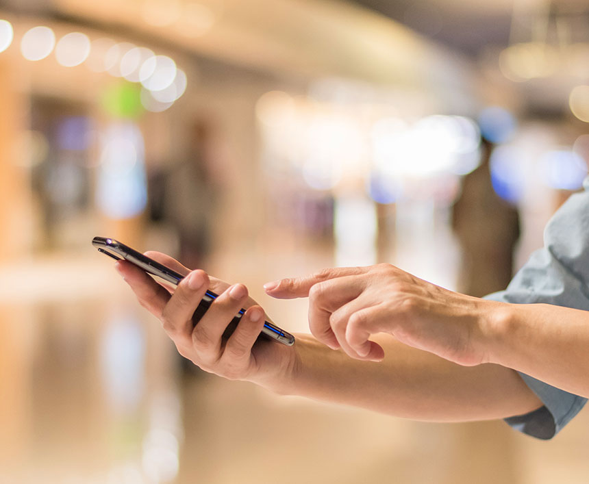 街中でスマートフォンで電話をかけようとしている人の手